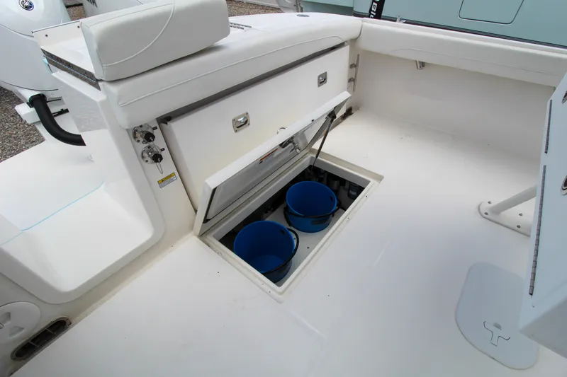 Slide: The Image of 2024 Regulator 23 boat storage compartment with blue buckets. - 18