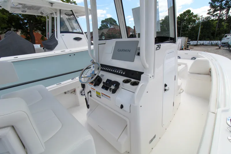 Slide: The Image of 2024 Regulator 23 boat cockpit with Garmin navigation system and white seating. - 20