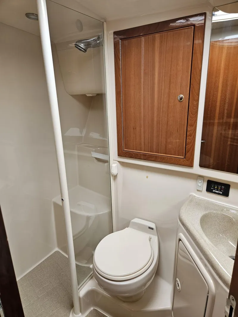 Slide: The Image of Bathroom interior of 2007 Riviera 42 yacht with shower, toilet, and wooden cabinetry. - 11