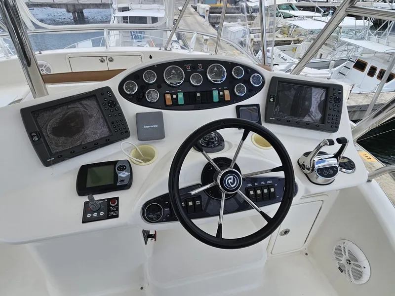 Slide: The Image of Control panel of a 2007 Riviera 42 yacht with navigation instruments and steering wheel. - 12