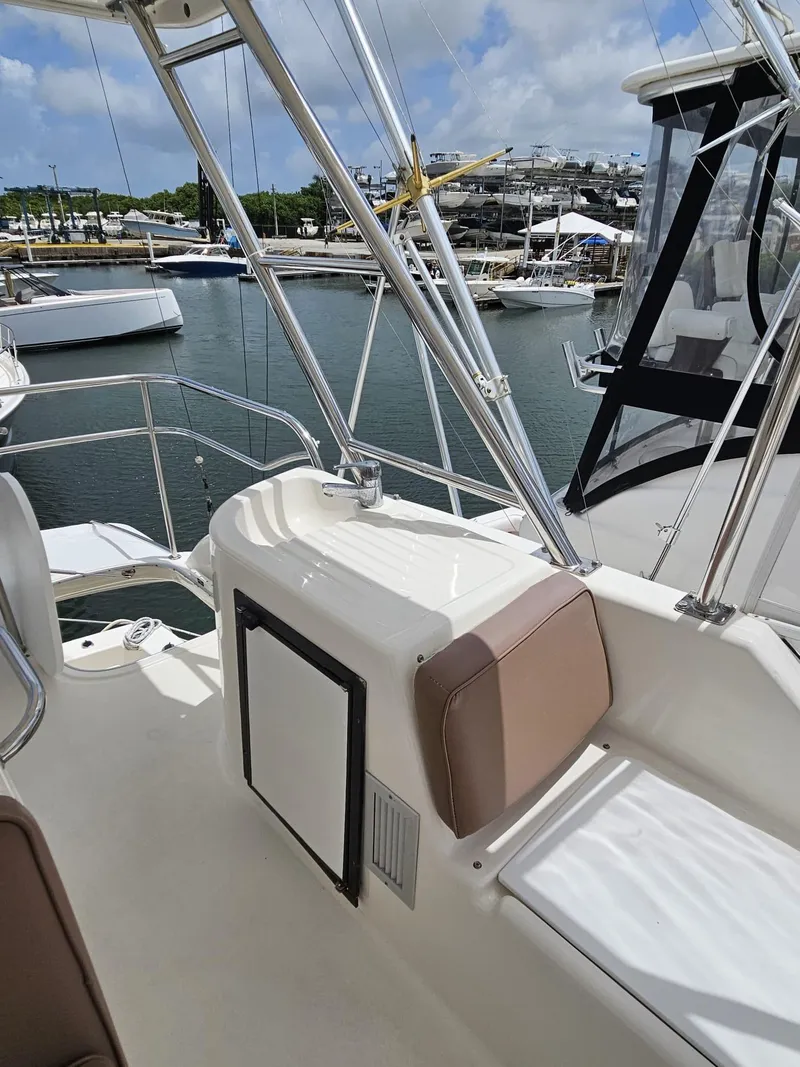 Slide: The Image of 2007 Riviera 42 yacht deck with seating, docked in marina under blue sky. - 16