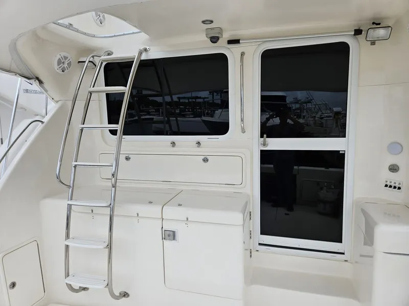 Slide: The Image of Riviera 42 2007 yacht with ladder and door, featuring sleek white design. - 2