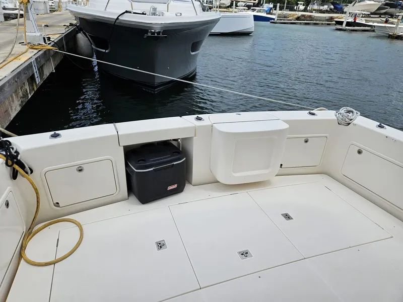 Slide: The Image of Riviera 42 2007 yacht deck with storage compartments and docked boats in marina. - 3