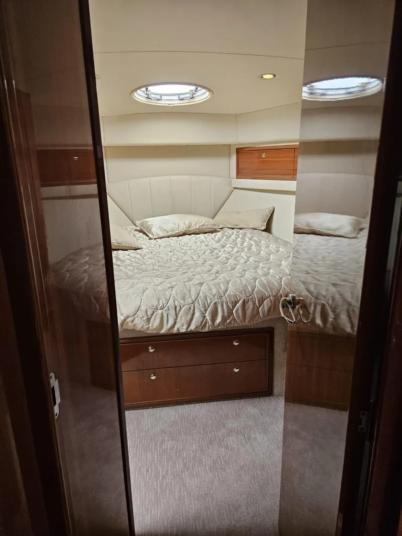 Slide: The Image of Luxurious bedroom interior of 2007 Riviera 42 yacht with cozy bedding and elegant wood accents. - 7