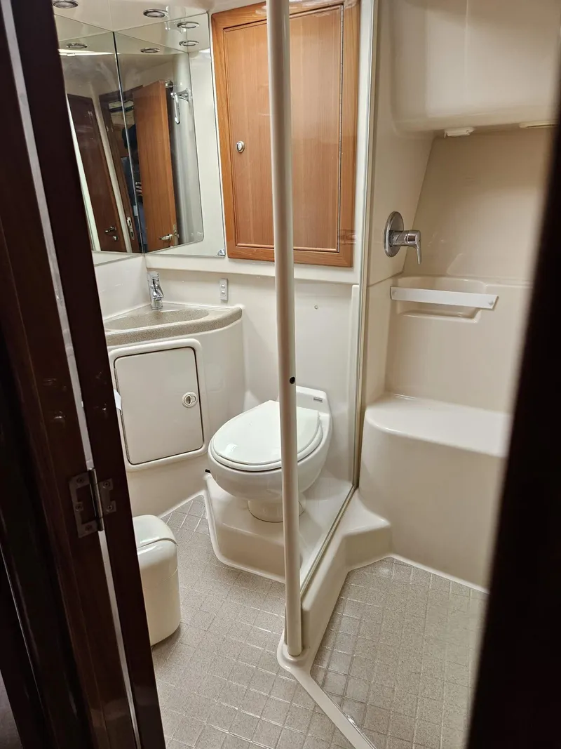 Slide: The Image of Bathroom interior of 2007 Riviera 42 yacht, featuring shower, toilet, and wooden cabinetry. - 9