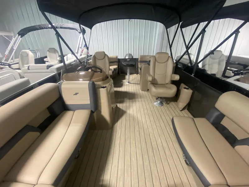 Slide: The Image of 2024 Starcraft EXS 1 pontoon boat interior with beige seating and black canopy. - 19