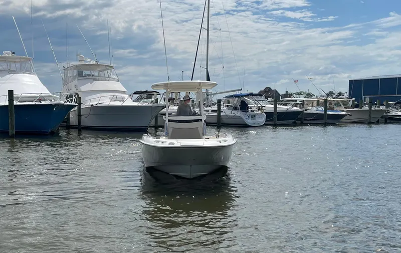 Slide: The Image of 2020 Boston Whaler 270 Dauntless boat docked at a marina with other vessels. - 3