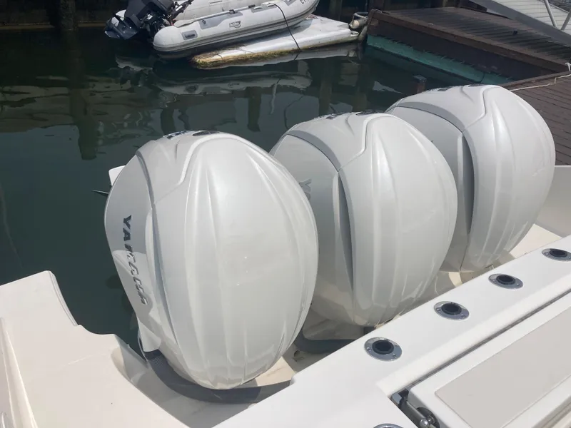 Slide: The Image of 2023 Pursuit DC 365 boat with triple Yamaha outboard engines. - 13