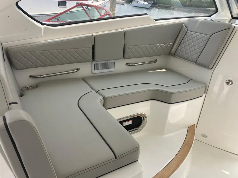 Slide: The Image of 2023 Pursuit DC 365 boat interior with luxurious gray seating. - 7