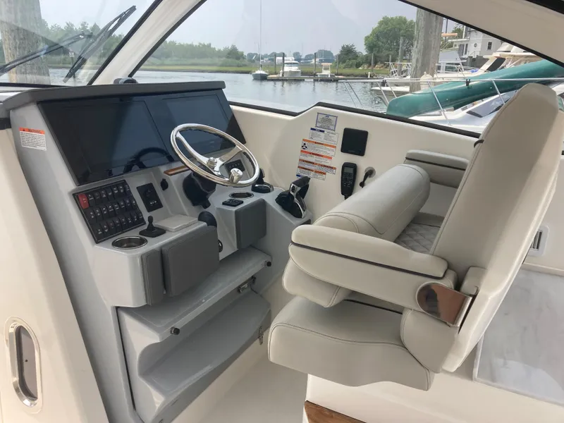 Slide: The Image of 2023 Pursuit DC 365 boat helm with modern controls and comfortable seating. - 8