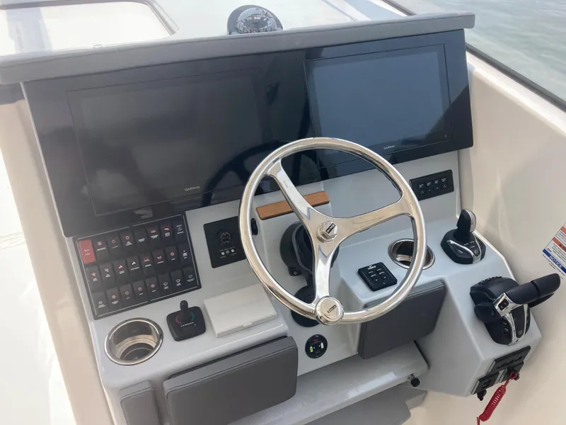 Slide: The Image of 2023 Pursuit DC 365 boat helm with dual screens and controls. - 9