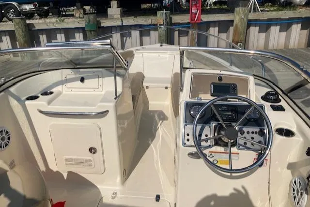 Slide: The Image of 2023 Scout 210 Dorado boat interior with steering wheel and control panel. - 2