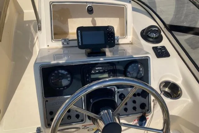 Slide: The Image of 2023 Scout 210 Dorado boat dashboard with steering wheel and navigation equipment. - 3