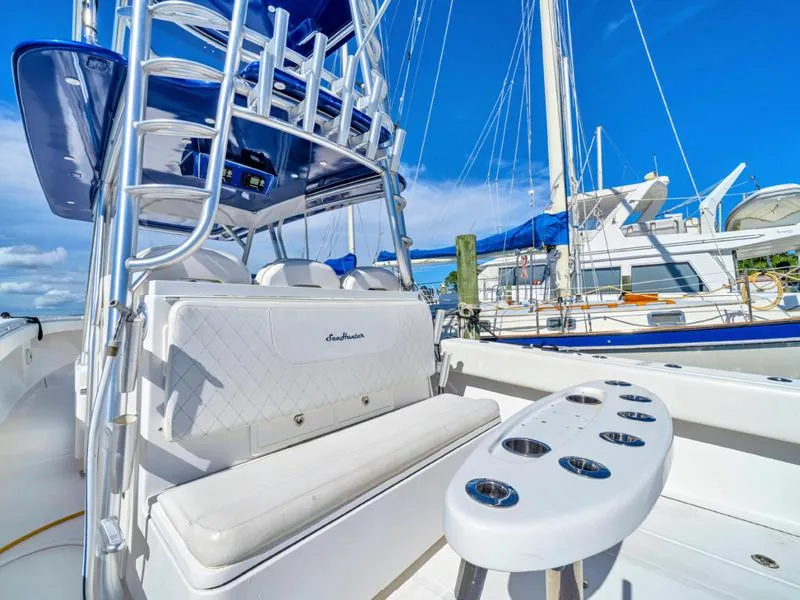 Slide: The Image of 2015 SeaHunter 45 boat with white seating and rod holders, docked at a marina. - 10