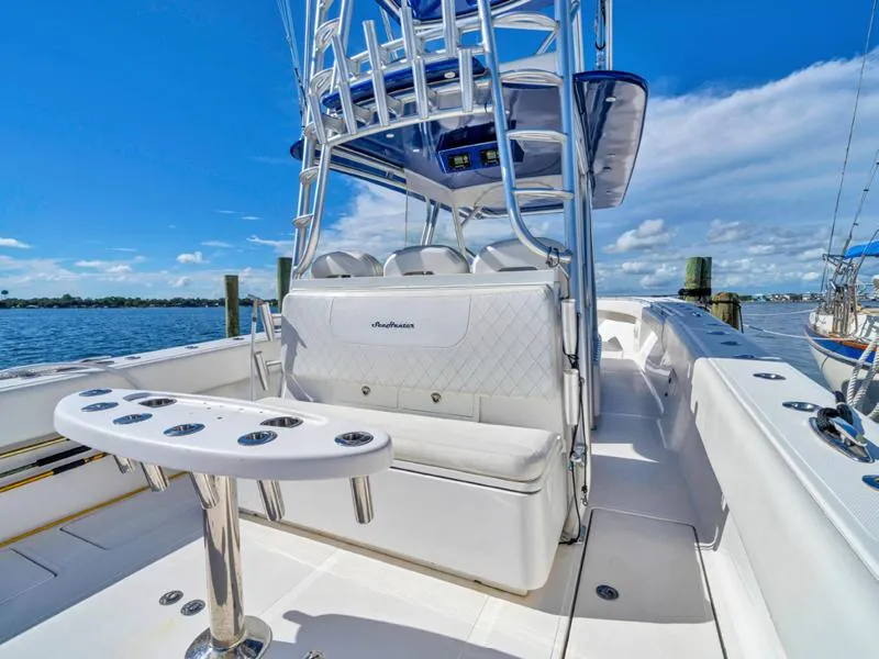 Slide: The Image of 2015 SeaHunter 45 boat with seating and rod holders, docked by the water. - 11