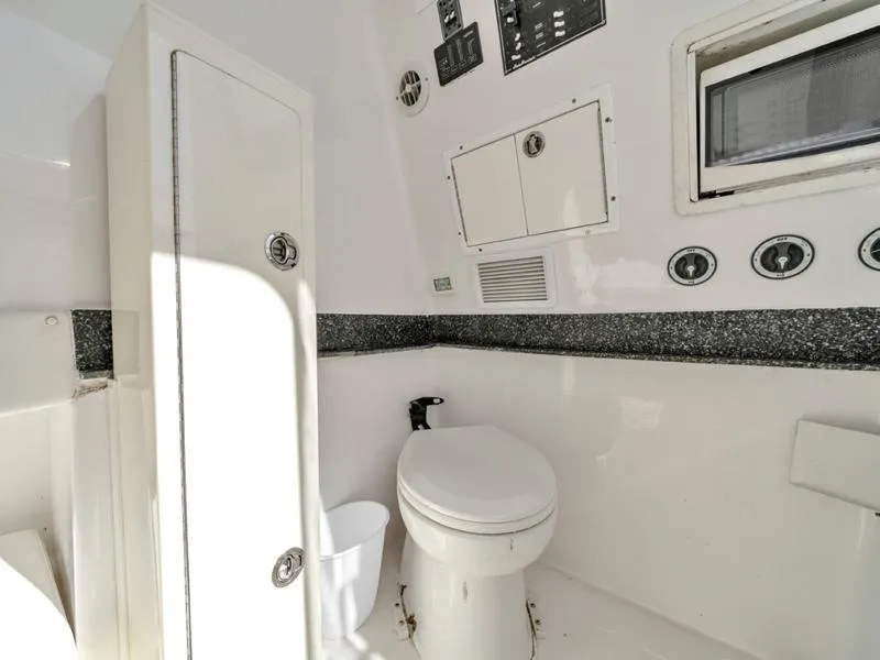 Slide: The Image of 2015 SeaHunter 45 boat bathroom with toilet and storage cabinets. - 17