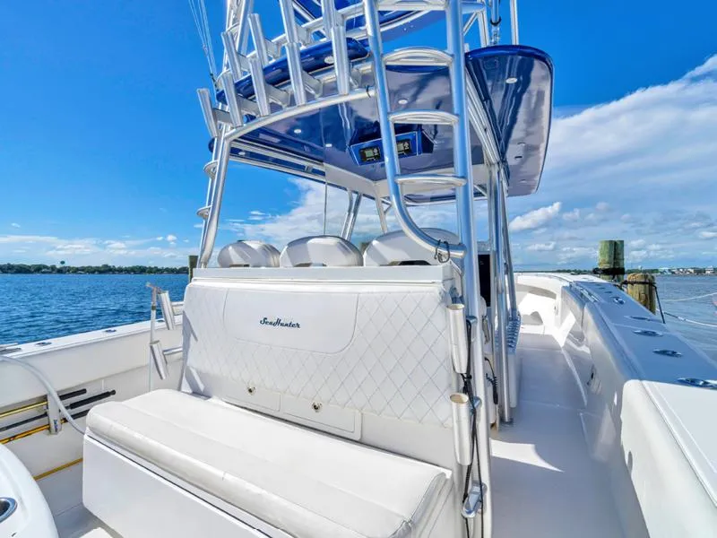 Slide: The Image of 2015 SeaHunter 45 boat with white seating and blue canopy on a sunny day. - 5