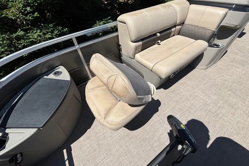 Slide: The Image of 2024 Sun Tracker Fishin' Barge 20 DLX interior with beige seating and fishing equipment. - 20