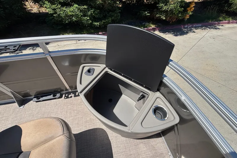 Slide: The Image of 2024 Sun Tracker Fishin' Barge 20 DLX boat interior with storage compartment and cup holder. - 34