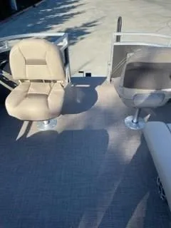 Slide: The Image of 2024 Sun Tracker Fishin' Barge 20 DLX boat interior with two beige seats. - 18