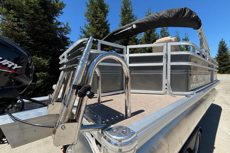 Slide: The Image of 2024 Sun Tracker Fishin' Barge 20 DLX pontoon boat with ladder and railing, outdoors. - 8