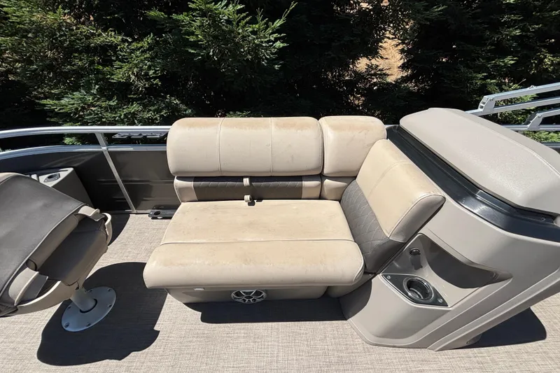 Slide: The Image of 2024 Sun Tracker Fishin' Barge 20 DLX interior seating with beige upholstery and cup holders. - 21