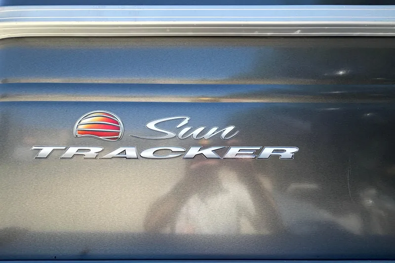 Slide: The Image of 2024 Sun Tracker Fishin' Barge 20 DLX logo on metallic surface. - 12