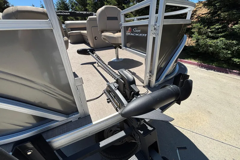 Slide: The Image of 2024 Sun Tracker Fishin' Barge 20 DLX pontoon boat with trolling motor on trailer. - 32