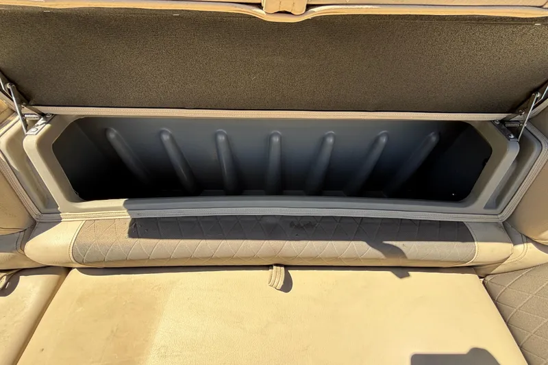 Slide: The Image of 2024 Sun Tracker Fishin' Barge 20 DLX storage compartment with open seat cushion. - 43