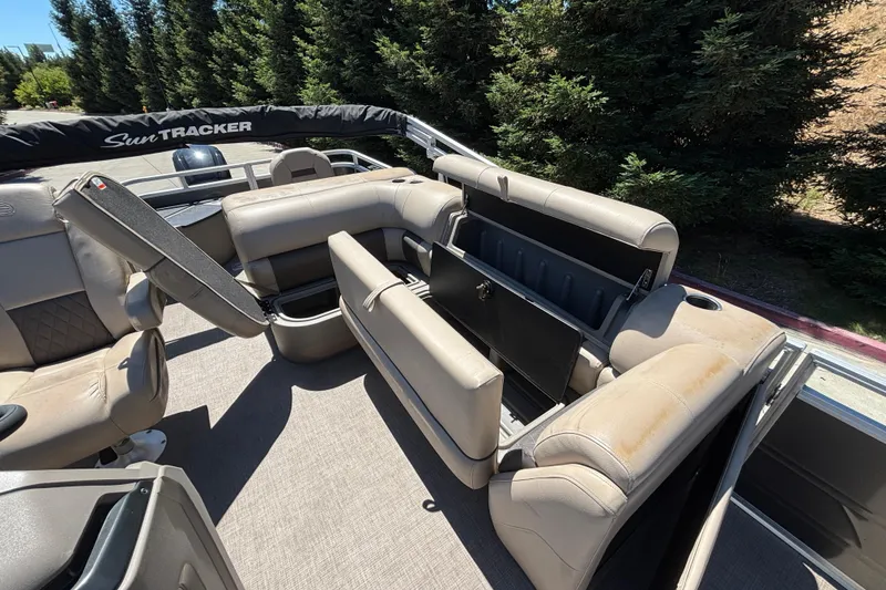 Slide: The Image of 2024 Sun Tracker Fishin' Barge 20 DLX interior with seating and storage compartments. - 40
