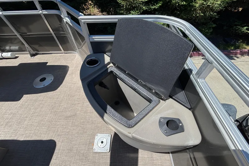 Slide: The Image of 2024 Sun Tracker Fishin' Barge 20 DLX with open storage compartment and cup holder. - 27