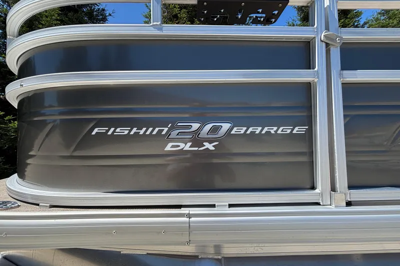 Slide: The Image of 2024 Sun Tracker Fishin' Barge 20 DLX pontoon boat side view with logo. - 11