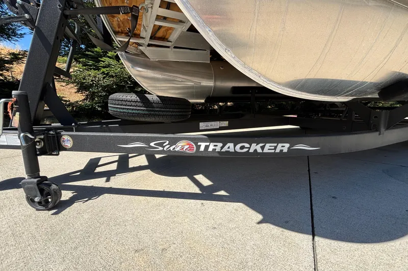 Slide: The Image of 2024 Sun Tracker Fishin' Barge 20 DLX trailer, parked on concrete, side view. - 15