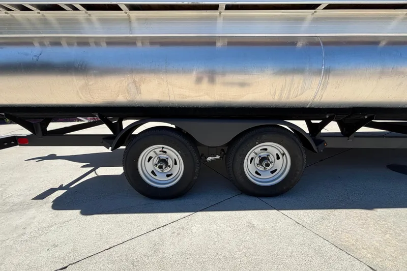 Slide: The Image of 2024 Sun Tracker Fishin' Barge 20 DLX trailer with dual wheels on concrete surface. - 28