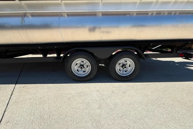 Slide: The Image of 2024 Sun Tracker Fishin' Barge 20 DLX trailer wheels on concrete surface. - 16