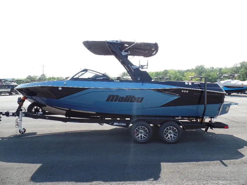 Slide: The Image of 2024 Malibu 23 LSV boat on trailer, sleek design, blue and black color scheme. - 4