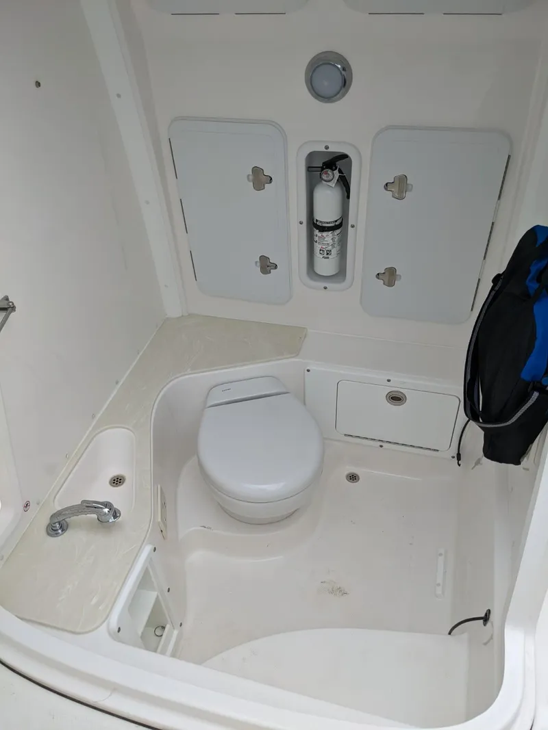 Slide: The Image of 2021 Edgewater 262 CC boat interior with marine toilet and storage compartments. - 15