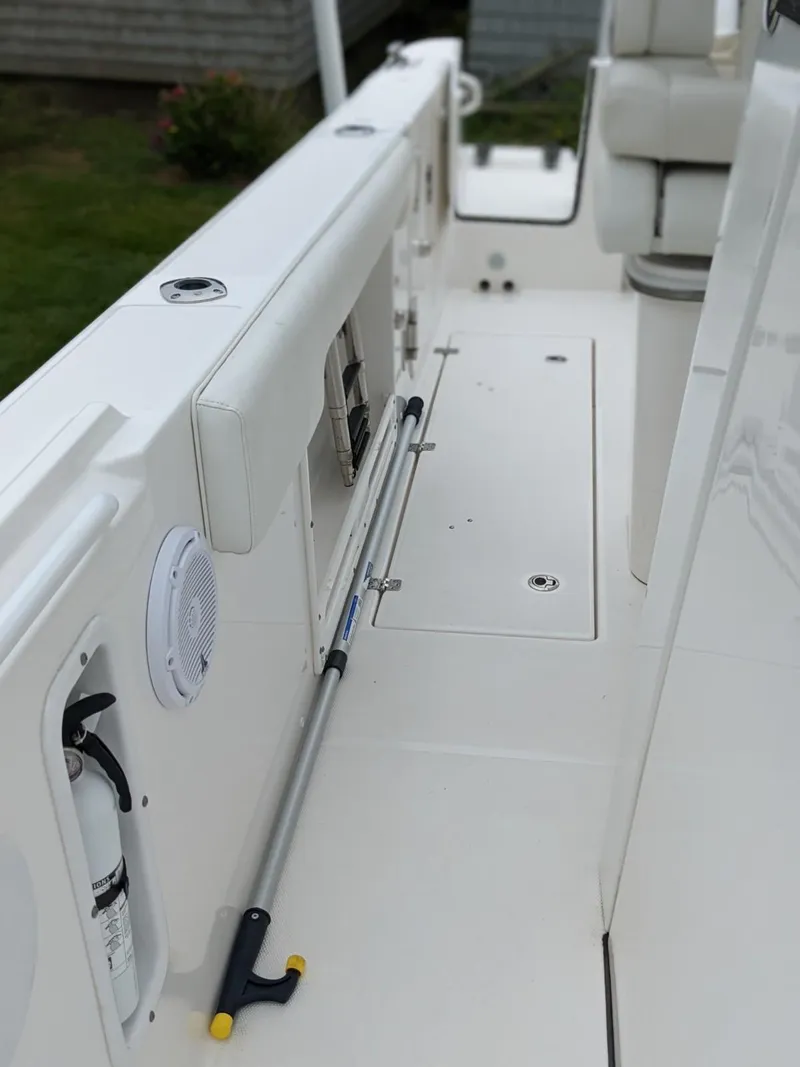 Slide: The Image of 2021 Edgewater 262 CC boat interior with white seating and safety equipment. - 18