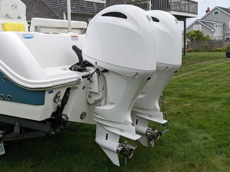 Slide: The Image of 2021 Edgewater 262 CC boat with dual outboard engines on grass. - 4