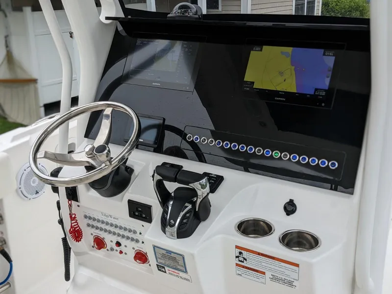 Slide: The Image of 2021 Edgewater 262 CC boat console with steering wheel, controls, and navigation screens. - 5