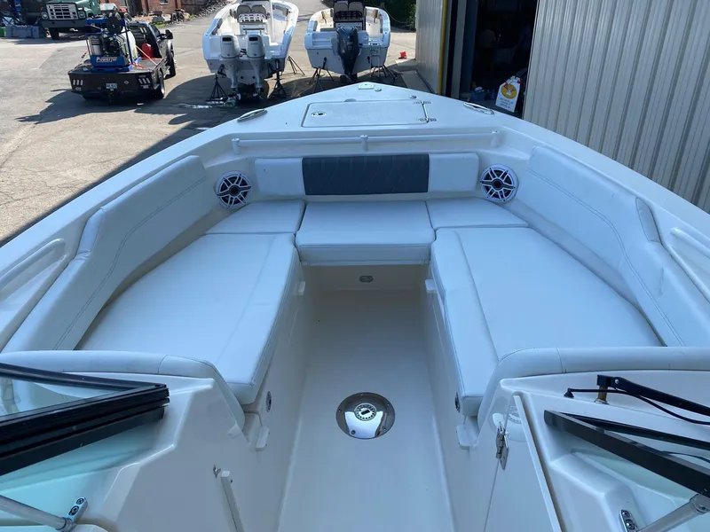 Slide: The Image of 2023 Cobia 240DC boat interior with white seating and speakers. - 6