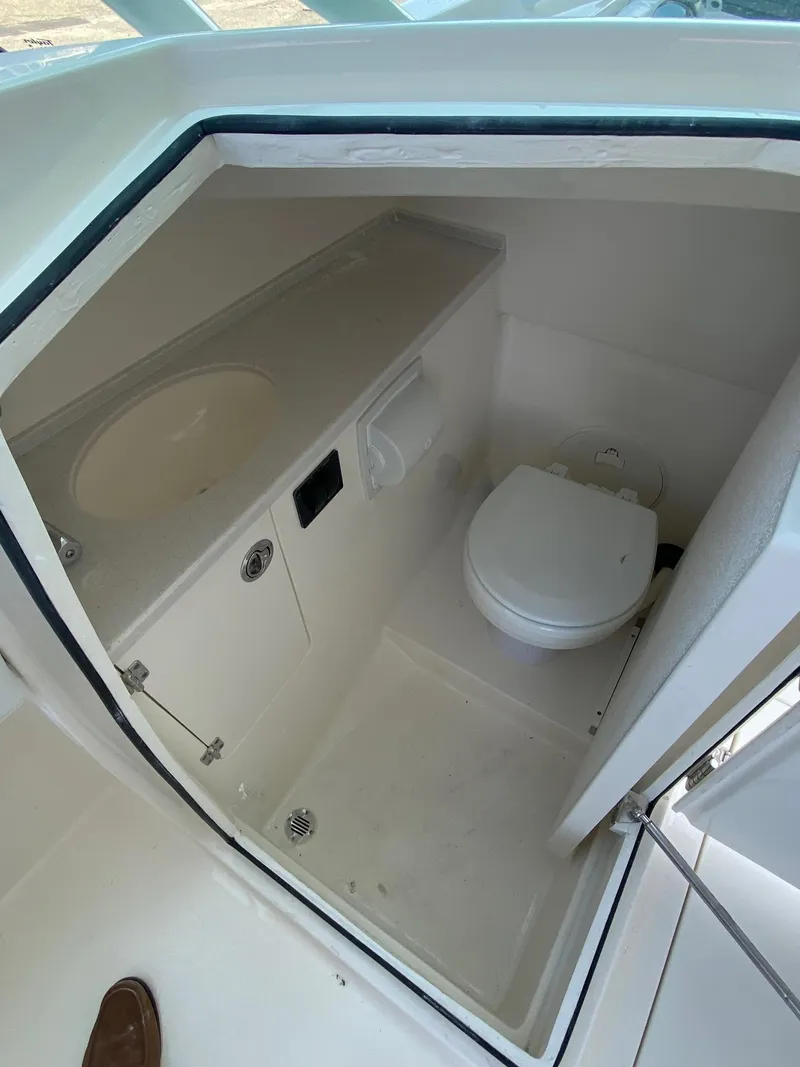 Slide: The Image of 2023 Cobia 240DC boat interior bathroom with sink and toilet. - 7