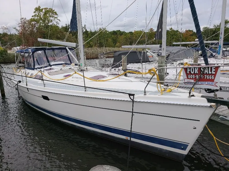 The Image of 2004 Hunter 466 sailboat docked, for sale sign visible, surrounded by other boats. - 0