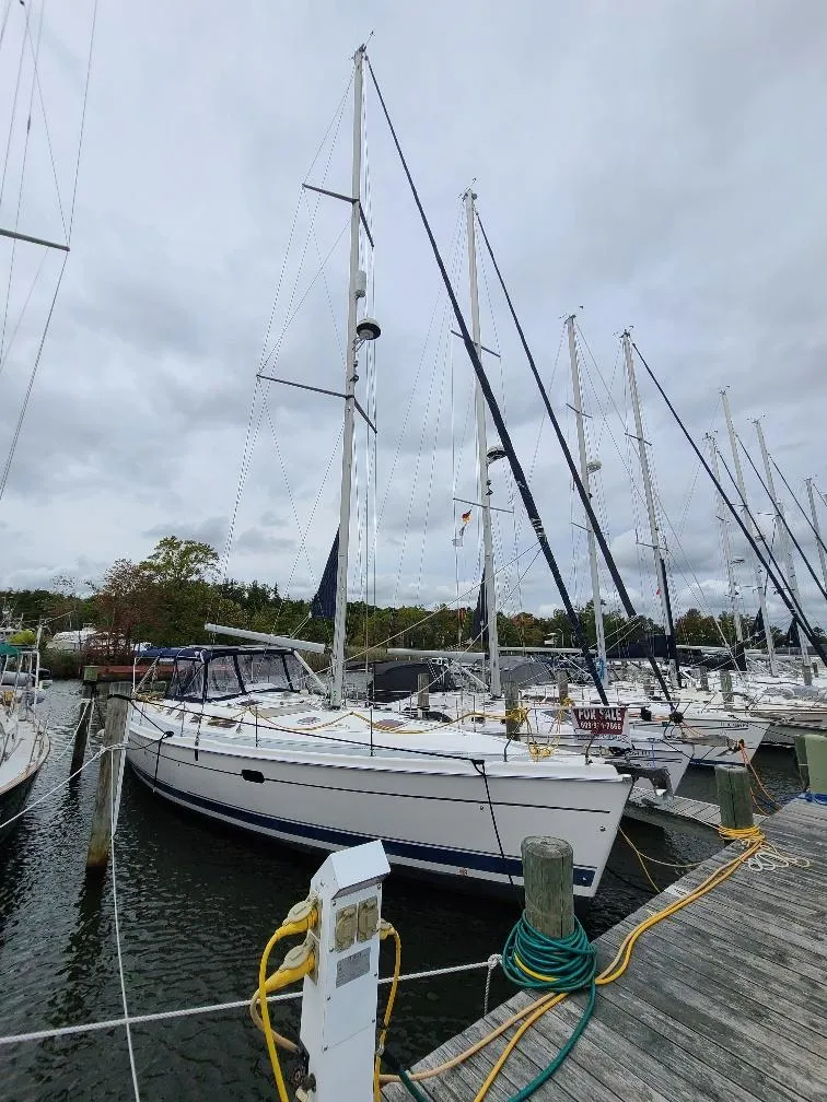 Slide: The Image of 2004 Hunter 466 sailboat docked at marina, overcast sky, for sale sign visible. - 15