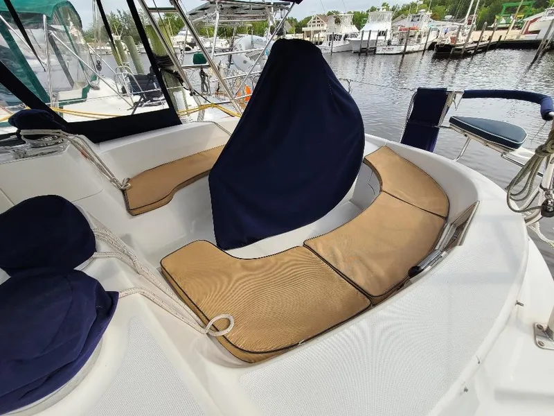 Slide: The Image of 2004 Hunter 466 yacht cockpit with tan cushions and covered helm, docked at marina. - 17