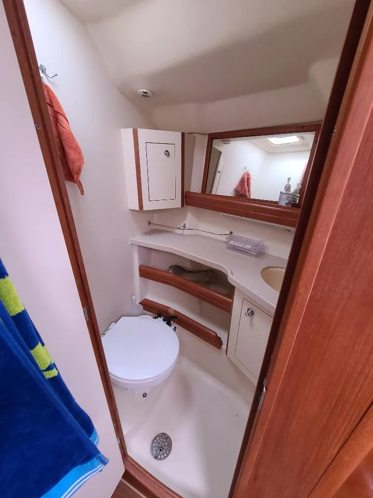 Slide: The Image of Compact bathroom in 2004 Hunter 466 yacht with toilet, sink, and mirror. - 19