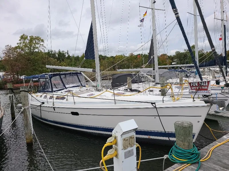 Slide: The Image of 2004 Hunter 466 sailboat docked, for sale, with visible masts and rigging. - 2