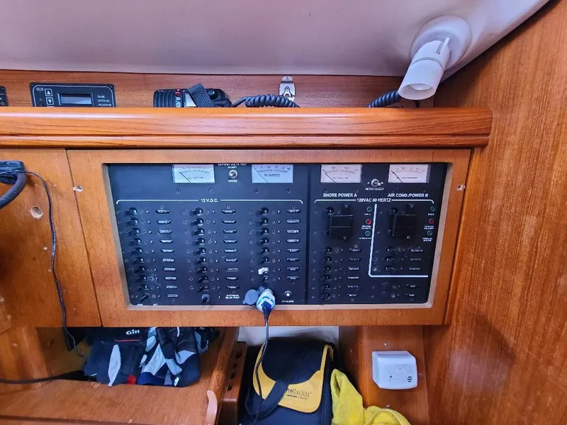 Slide: The Image of Electrical control panel on a 2004 Hunter 466 sailboat, featuring various switches and meters. - 24