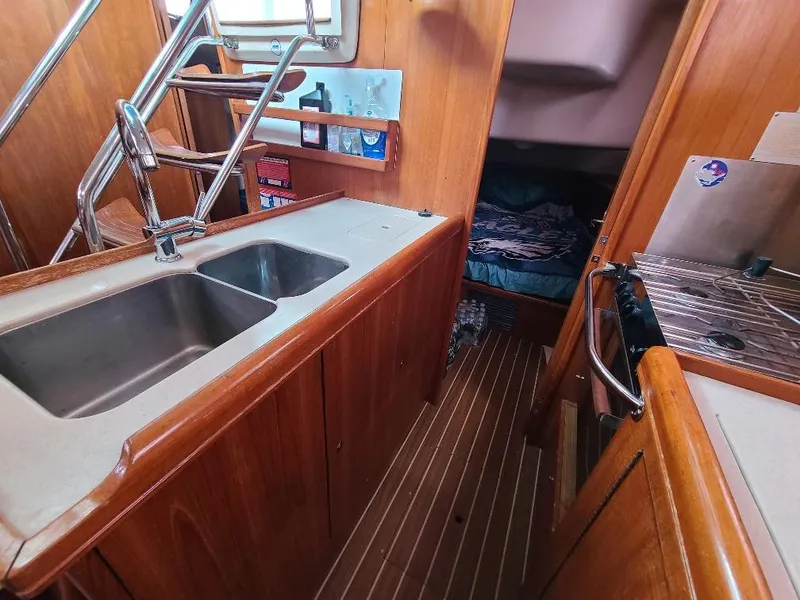Slide: The Image of Interior of 2004 Hunter 466 sailboat with wooden cabinetry and stainless steel sink. - 27