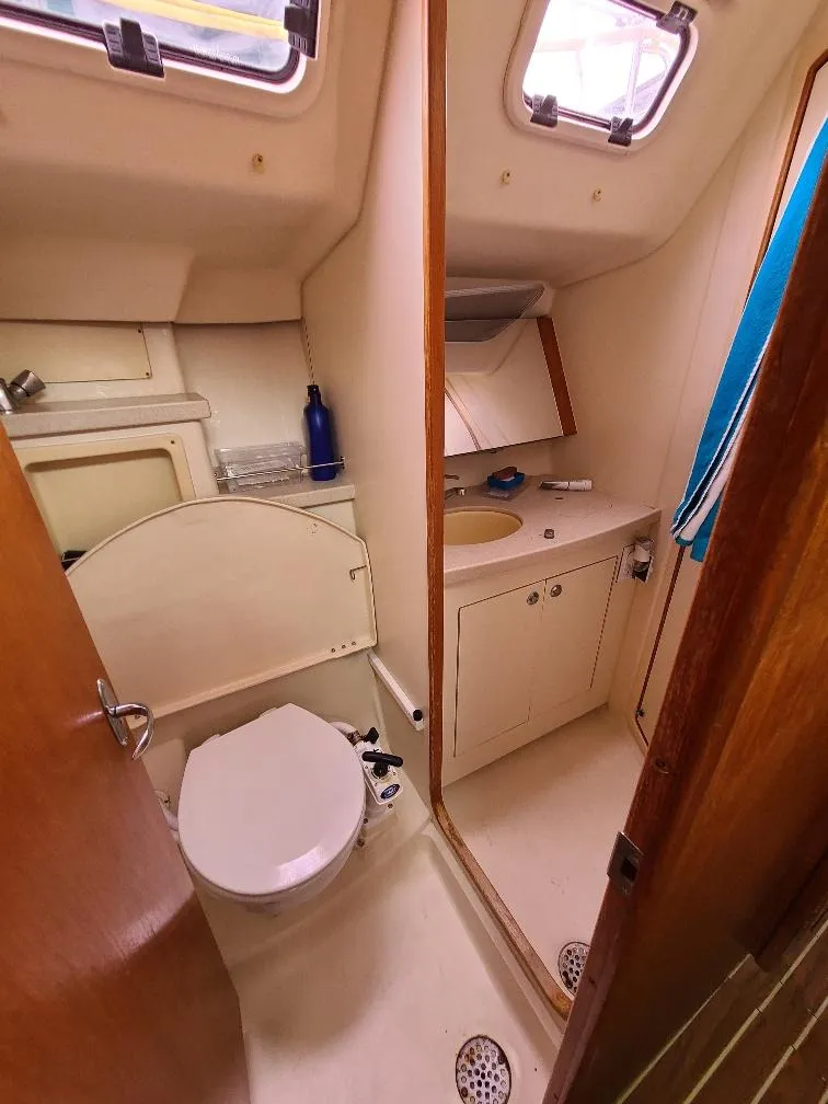 Slide: The Image of Compact bathroom in 2004 Hunter 466 yacht with toilet, sink, and storage. - 29